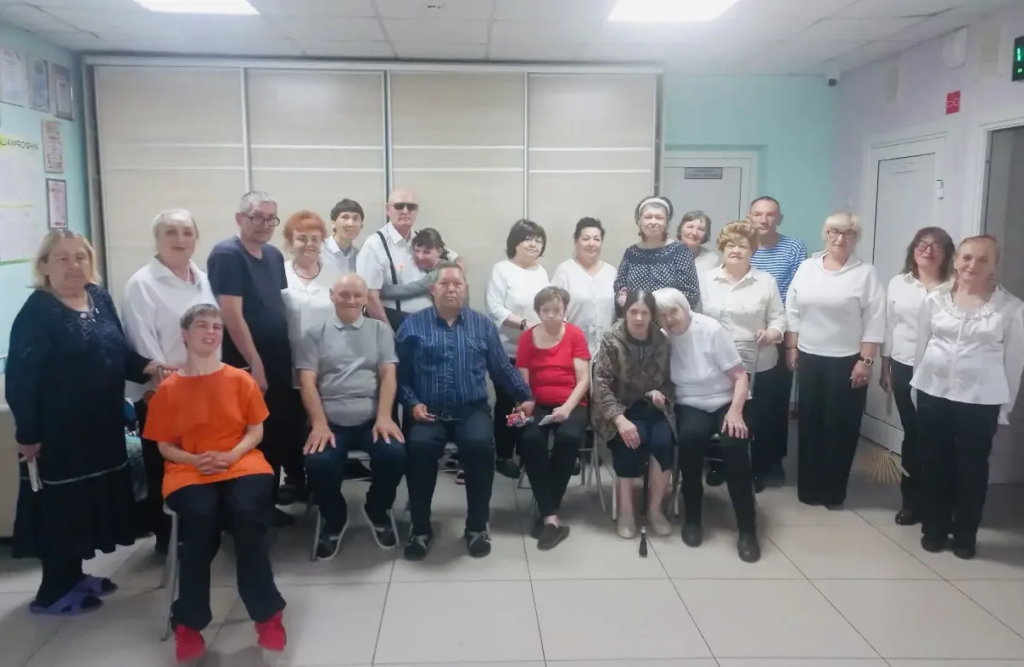 На фотографии запечатлена большая группа людей, участники коллектива и получатели социальных услуг.